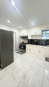 a kitchen with white cabinets and a large marble floor at Luxurious 2 Bedroom Apartment- Georgetown in Georgetown