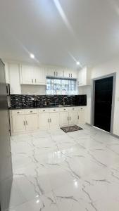a kitchen with white cabinets and a marble floor at Luxurious 2 Bedroom Apartment- Georgetown in Georgetown