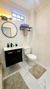 a white bathroom with a toilet and a mirror at Luxurious 2 Bedroom Apartment- Georgetown in Georgetown