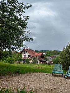 duas cadeiras azuis sentadas em frente a uma casa em Pensiunea Mara em Deseşti