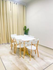 a white table and chairs in a room with curtains at Ar-Rayyan 2 Homestay Kota Bharu in Kota Bharu