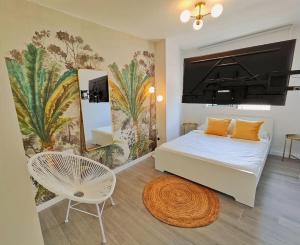a bedroom with a bed and a chair and a mural at El mirador de La Concha in Oropesa del Mar