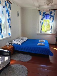 una camera con un letto blu e due finestre di Zielony Domek 