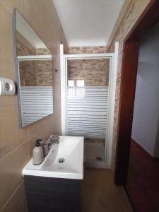 a bathroom with a sink and a mirror and a window at Casa Kunkapi in Portimão +3 photos