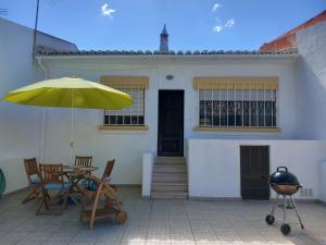 a patio with a table and a yellow umbrella at Casa Kunkapi in Portimão