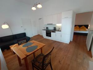 a kitchen and a living room with a table and chairs at Seeappartements Villa Sole in Pörtschach am Wörthersee