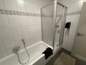 un bagno con doccia e vasca da bagno di Ferienwohnung Mia a Niestetal Altre 7 foto