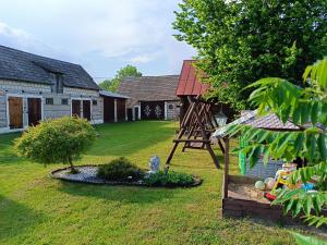 a yard with a playground in front of a house at Zielony Domek nad Biebrzą in Zabiele