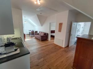 a kitchen and living room with a couch and wooden floors at Seeappartements Villa Sole in Pörtschach am Wörthersee