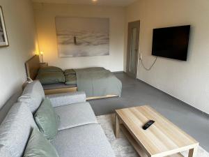 un soggiorno con un divano e un letto di Ferienwohnung Mia a Niestetal