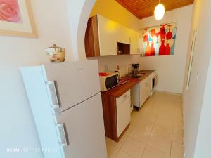 a kitchen with a white refrigerator and a microwave at Spasmata Village- Adults Only Houses Full Sea View Near Beach Quiet Escape in Minia