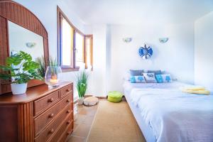 sypialnia z łóżkiem i komodą z lustrem w obiekcie Apartamento Boho, Punta Prima, Panorama Park,close to the beach plus 2 beautiful swimming pools w mieście Punta Prima