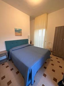 una camera da letto con un letto con una coperta blu sopra di Albergo Godenizzo a Peschici