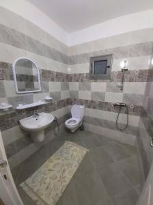 ein Badezimmer mit einem Waschbecken und einem TV an der Wand in der Unterkunft Villa TAGUERMES in Taguermess