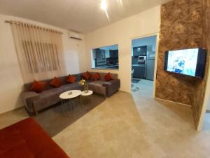 ein Wohnzimmer mit Couch und Flachbildfernseher in der Unterkunft Villa TAGUERMES in Taguermess