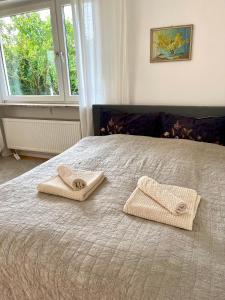 a bedroom with a bed with two towels on it at Aubing Süd in Munich