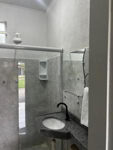 La salle de bains est pourvue d'un lavabo et d'un miroir. dans l'établissement Pousada Riviera - Praia de Lagoa do Pau, à Coruripe