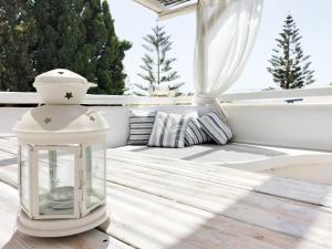 una lanterna seduta su un tavolo di legno su un portico di Angelina Greek House a Paroikia Altre 38 foto