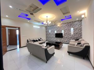 duży salon z kanapami i telewizorem w obiekcie Luxury Holiday Home in Islamabad w mieście Islamabad