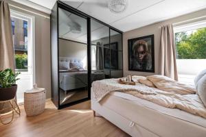 una camera da letto con un grande letto e un grande specchio di Stor leilighet med 4 soverom,stor terrasse og hage a Fornebu