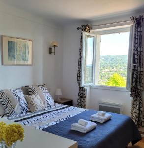 a bedroom with a bed with towels on top of it at Le Jardin des Oliviers in Apt