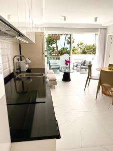 a kitchen with a black counter top and a living room at Sun Island in Adeje +35 photos