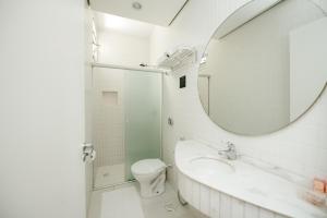 a bathroom with a sink and a toilet and a mirror at Hotel Himmelblau Blumenau - Centro de Blumenau, próximo ao Neumarkt Shopping in Blumenau