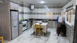 a kitchen with a table and a refrigerator at شاليه جبال سوف in Jerash