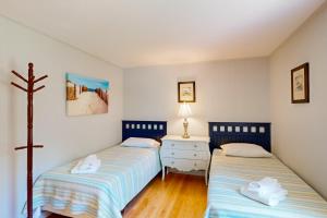 ein Schlafzimmer mit 2 Betten und einem Kreuz an der Wand in der Unterkunft The Blue Whale Cottage in Brewster