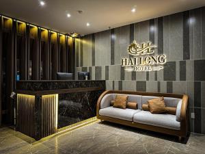 a couch in a lobby with a sign on the wall at Hải Long Hotel 1 in Vung Tau