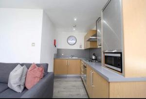 een woonkamer met een bank en een keuken bij Campbell Square Apartment 3 in Liverpool