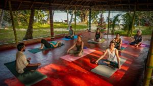 a group of people sitting in a yoga class at Vishram Village in Varkala