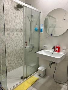 uma casa de banho com um chuveiro e um lavatório. em Comfort Central Point apartment em Podgorica