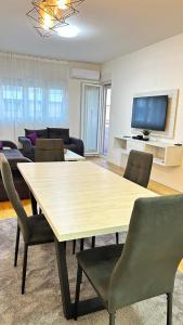 uma sala de estar com mesa e cadeiras em Comfort Central Point apartment em Podgorica