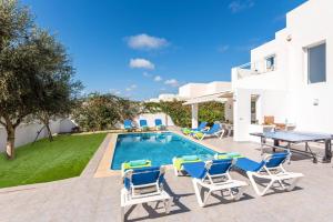 Una villa con piscina, mesa y sillas. en Villa Atalis by Villa Plus, en Alaior