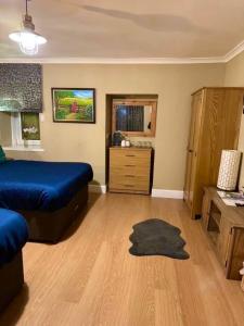 a bedroom with a blue bed and a wooden floor at The Milton Accommodation in Elgin