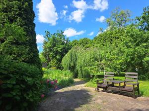 dos bancos en un jardín con flores y árboles en Champêtre Park View Apartments en Riga
