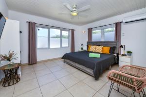 um quarto com uma cama e uma ventoinha de tecto em Sunny Palm Beach Villa em Palm-Eagle Beach