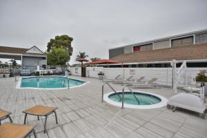 un patio con piscina, mesas y sillas en Best Western Surf City, en Huntington Beach