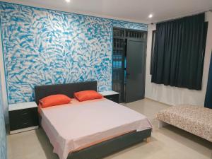 a bedroom with a bed and a blue and white wall at Residencial Oliveira in Porto Novo