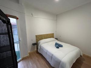 a bedroom with a bed with a blue stuffed animal on it at Apartamento Libertad in Elda