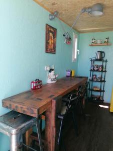 a wooden table in a room with two chairs and a table at Le Pick up 403 vintage in Oradour-sur-Glane