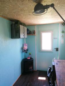 a room with blue walls and a table and a window at Le Pick up 403 vintage in Oradour-sur-Glane
