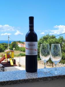a bottle of wine and two glasses on a table at Santorini by Jasna in Vir +5 photos