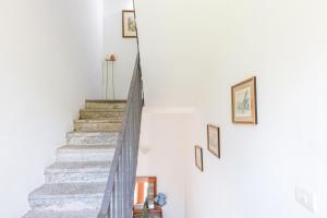 una escalera en una casa con fotos en la pared en Appartamenti Villa Giulia, en Bellagio