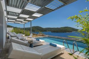 eine Terrasse mit einem Pool und eine Villa in der Unterkunft Adrina Grand Hotel in Panormos Skopelos