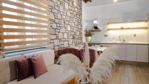 salon z kanapą i kamienną ścianą w obiekcie Lithoessa Luxury Apartments w mieście Agios Ioannis Kaspaka