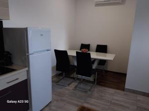 a kitchen with a refrigerator and a table with chairs at JUDITA in Omiš