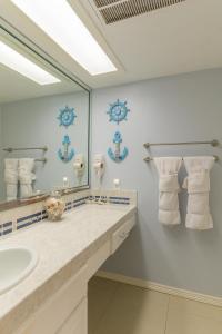 uma casa de banho com um lavatório e um espelho grande em Tiki 259 em South Padre Island