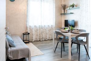 a dining room with a white table and chairs at Appartamento Rayan Alba Wine Retreat nelle Langhe in Alba